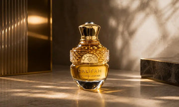 Luxury amber perfume bottle on an elegant marble surface with warm golden lighting and a refined architectural background.