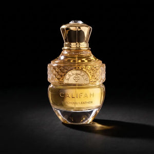 A bottle of Califah Patchouli Leather Parfum with a faceted gold cap and a clear glass body showing golden liquid, set against a solid black background.