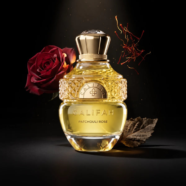 CALIFAH Patchouli Rose perfume bottle with a red rose, saffron threads and a dried leaf against a black background.