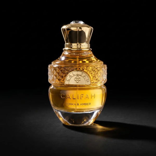 A bottle of Califah Tonka & Amber Parfum with a textured gold cap and golden liquid inside a clear glass bottle, set against a solid black background.